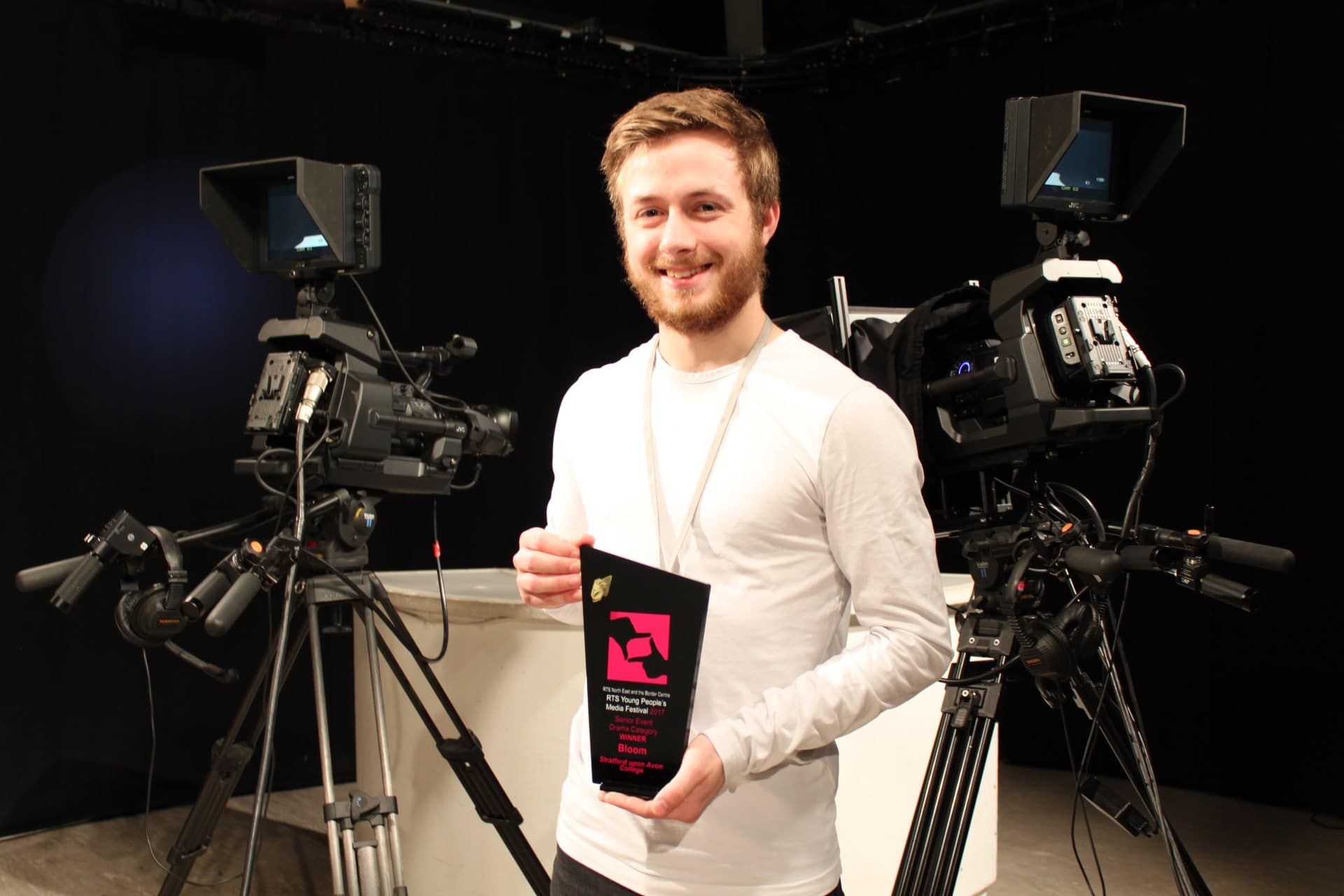 Alexander Eves proudly holding his award in Stratford-upon-College’s television studio.