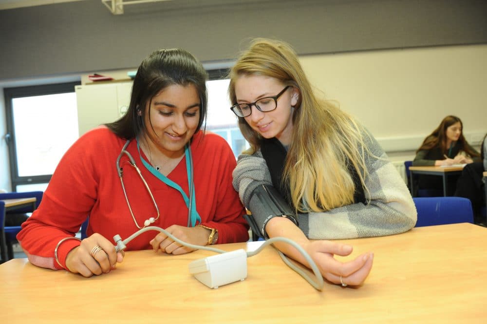 student taking blood pressure of other pupil