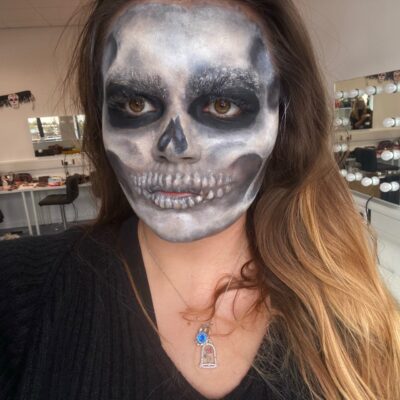 Student's face with grey skull make up on