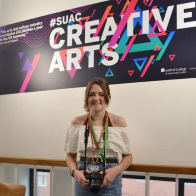 Student standing in front of "Creative Arts" Sign