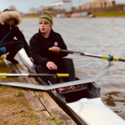 Student sat in boat holding oars