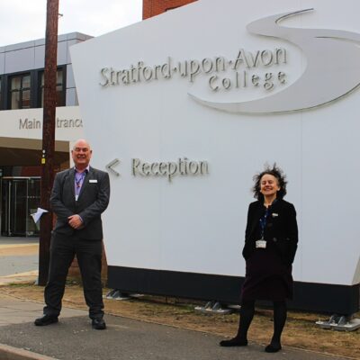 Principals standing in front of Stratford-upon-Avon College Reception sign