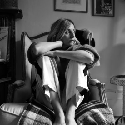 Sinead sitting on chair looking to her left in black and white