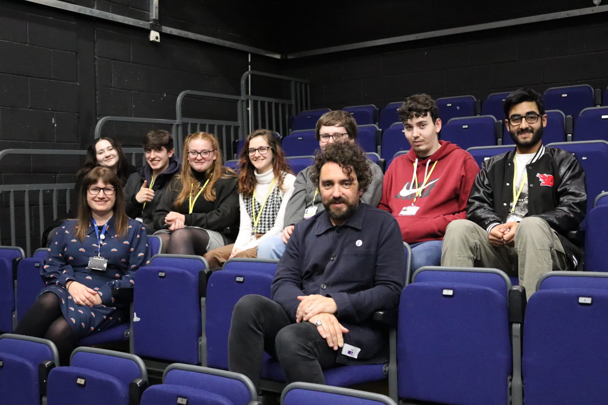 Greg McLeod sitting with students and tutor at stratford-upon-avon college
