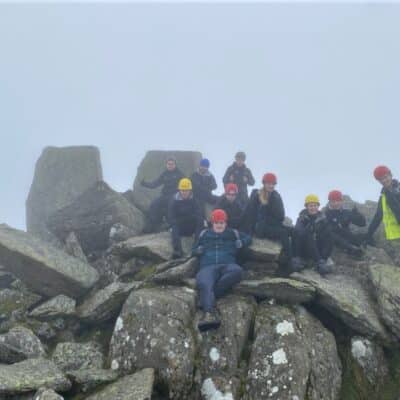 Students on rocks with helments and hi vis jackets on in Wales