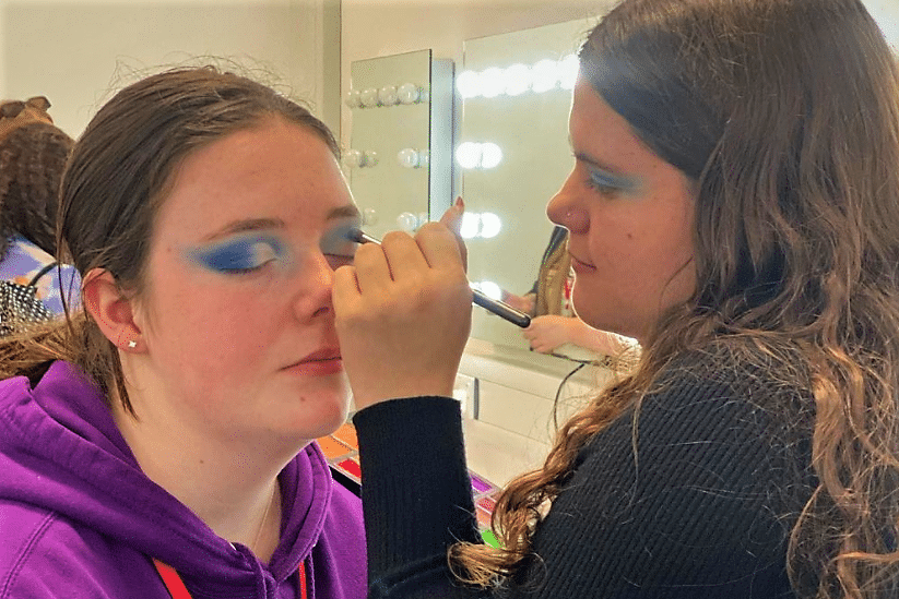 Alice doing make up on student Maddy