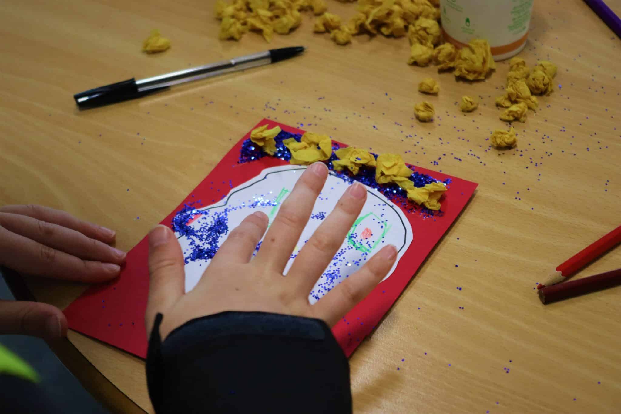 Hand painting a coronation craft at coronation event with the local community