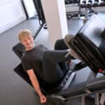 Stratford-upon-Avon College student uses leg press gym machine.
