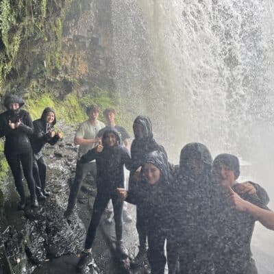 students underneath waterfall
