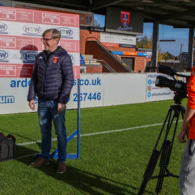 student alex filming interview at football club