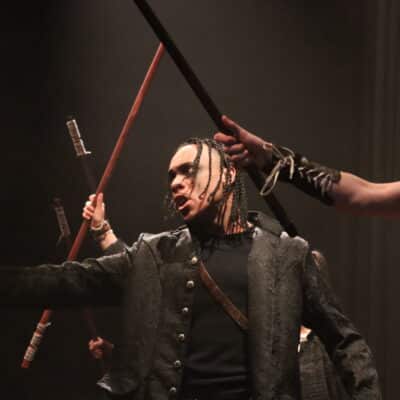 Stratford College Actors holding swords on stage.