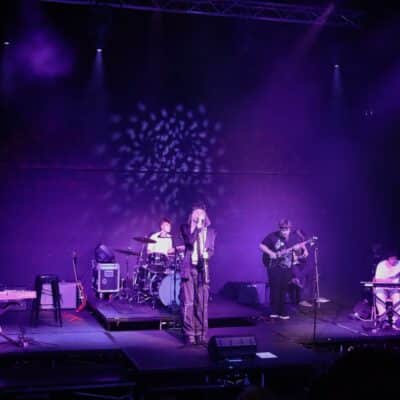 Stratford College Students perform a concert on a stage under purple lights