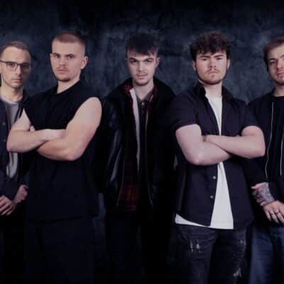 Group of men posing by a dark background