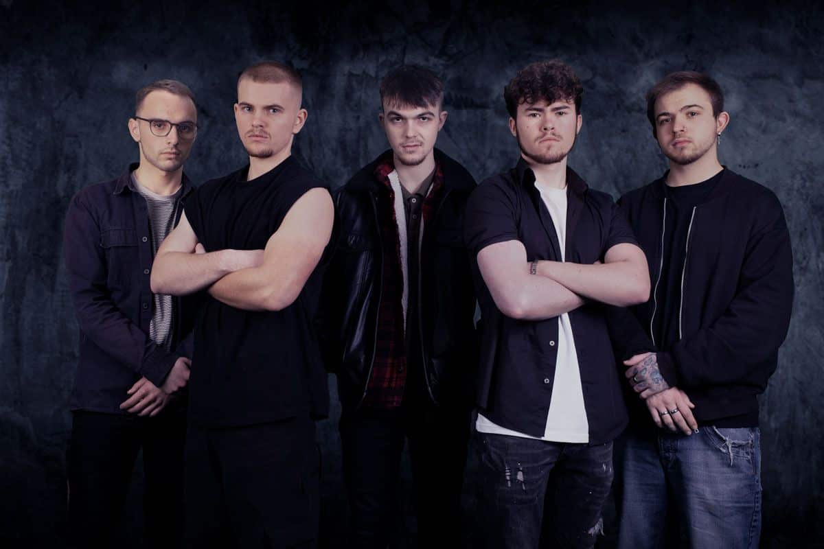 Group of men posing by a dark background