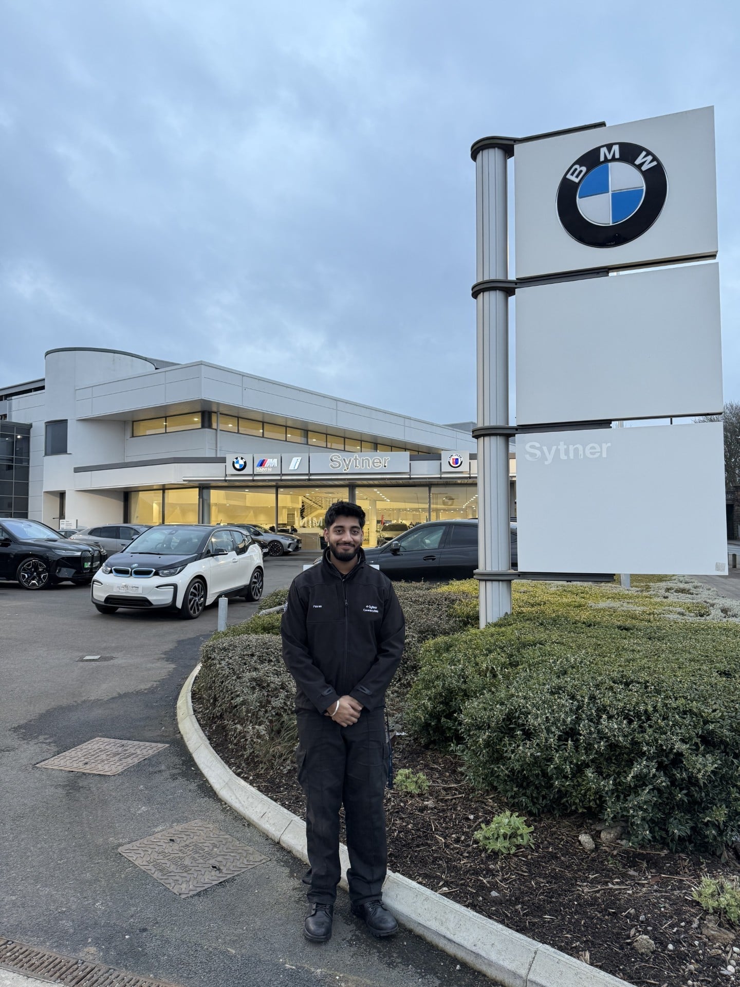 Man stood in front of BMW sign