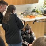 2 people stod around a camera